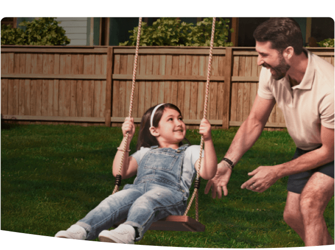 A father pushing his daughter on a swing